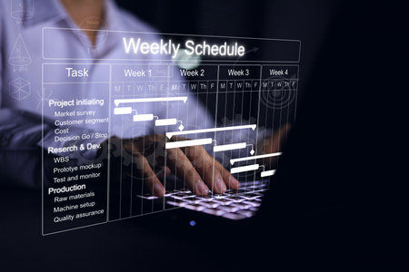 Businessman working with project management schedule plan for product production or Research and Development and recording weekly project progression.の写真素材