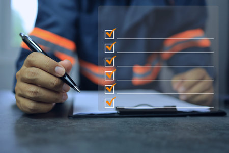 An industrial or shipping inspector auditor supervisor in a reflective jacket is writing a pen on a...