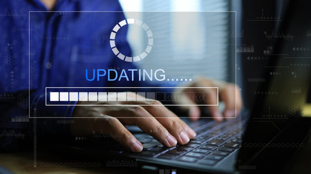 The hand is using the computer and the programs or software are being updated in order to use it effectively and always up to date.の写真素材