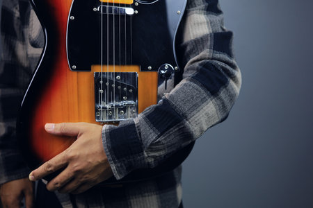 Guitarist holding solid body electric guitar sunburst yellow maple fingerboardの写真素材