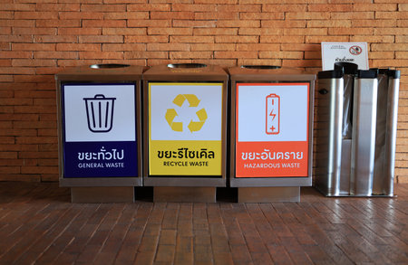 Waste bins made of metal and labeled to separate waste such as general waste, recyclable waste and hazardous waste are installed in public places to protect the environment.の写真素材