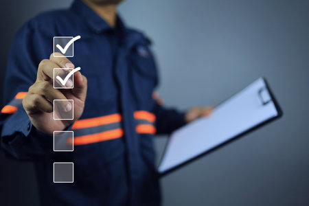 Engineer with clipboard using pen to tick correct sign or check mark on checkbox to complete task and things to do checklist in document control syetem. Project approve and audit done concept.の写真素材
