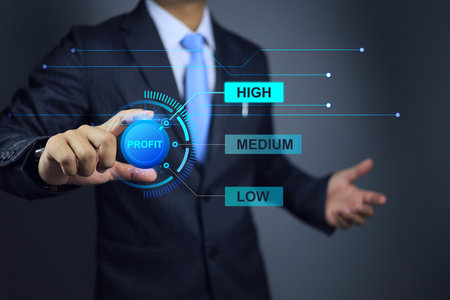Businessman aiming target to high revenue by turning the profit volume knob to high is a challenge in business and requires knowledge of management to resources and production costs as well.の写真素材