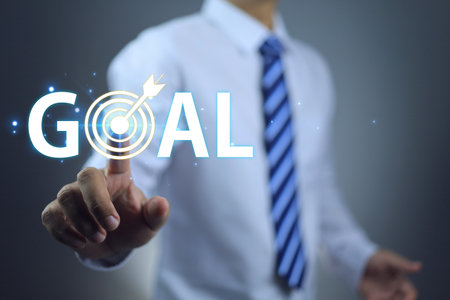 Businessman touching the word goal setting business target such as expanding the market, gaining more profits, promoted higher position and achieving success in other side of life.の写真素材