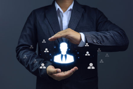 Businessman holding a job candidate in his hand to choose a suitable job for the position. Human resources department holding employee icons development educating employees staff training HR concept.の写真素材