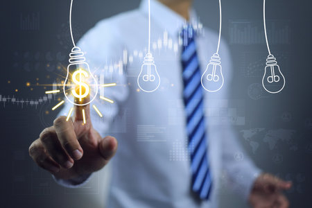 Businessman hand touch on revenue chart light bulb with dollar sign, symbol conveying the creativity of investment financial idea digital marketing strategy to grow expand business on global scale.の写真素材