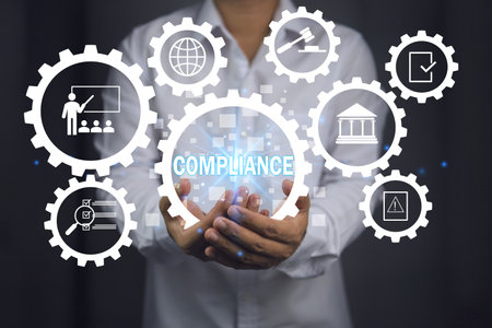 Compliance concept. Businessman in white holding cog to applied standards compliance. Concept of legal certification of different countries or procedures for import and export of goods.の写真素材