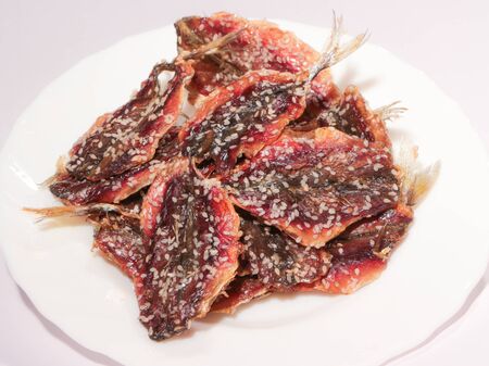 The dried fish is placed on a white plate.の写真素材