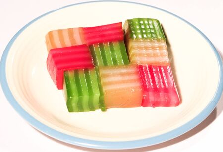 Many colored sweets are placed on a white plate.の写真素材