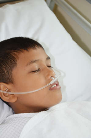 Sick boy sleeping with oxygen line on his nose の写真素材