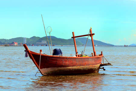 Fishing boat on the shore at low tide の写真素材