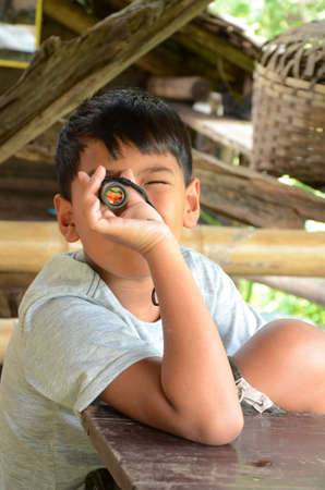 Asian boy playing with his monocular の写真素材
