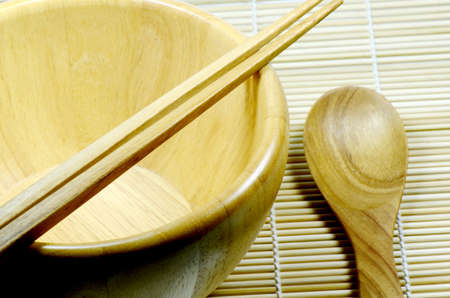 Teak wood kitchenware on bamboo mat background の写真素材
