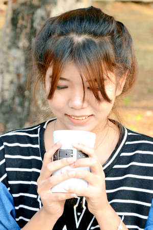 Portrait of young beautiful Asian woman with coffee cup の写真素材