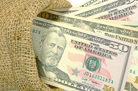 Dollar Banknotes in Burlap Sack Isolated on White の写真素材