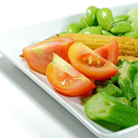 Mixed vegetable menu with sliced cucumber, tomatoes, grilled baby corn, boiled okra and fresh stink beans mostly served with Shrimp-paste sauce in Thai food menu の写真素材