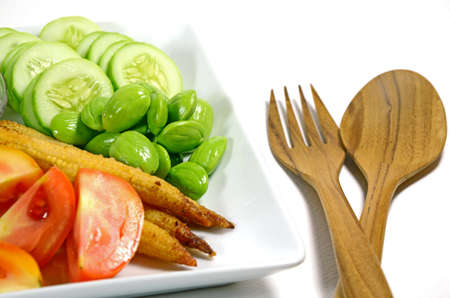 Mixed vegetable menu with sliced cucumber, tomatoes, grilled baby corn, boiled okra and fresh stink beans mostly served with Shrimp-paste sauce in Thai food menu の写真素材