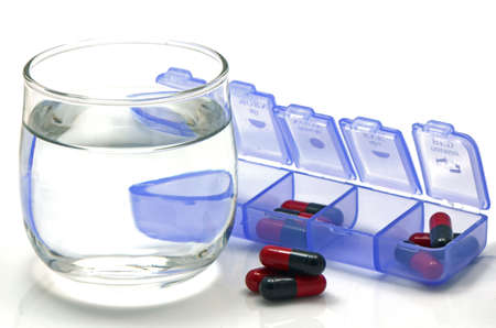 Oral medication red and black capsules in separated unit-dose box on whiteの写真素材