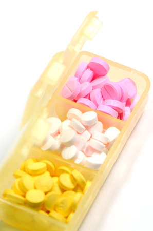 Pills in separated container isolated on white backgroundの写真素材