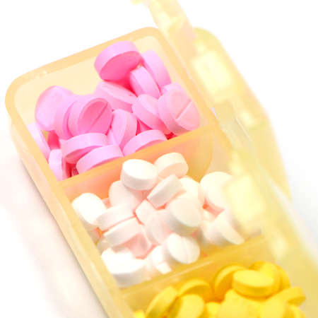 Pills in separated container isolated on white backgroundの写真素材