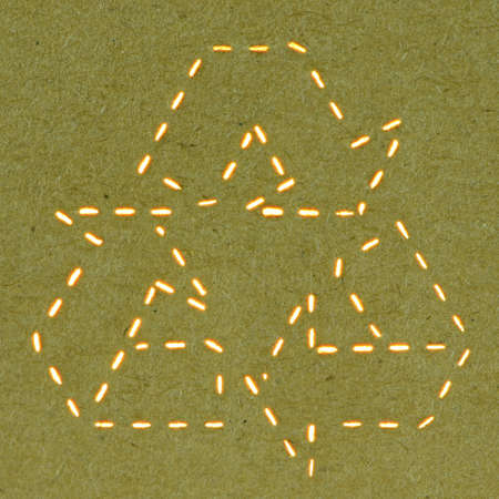 Laser Cut of Recycle Sign on Dark Paper Cardboard Background の写真素材