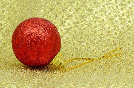 Red Decorating Ball on Golden Background Texture の写真素材