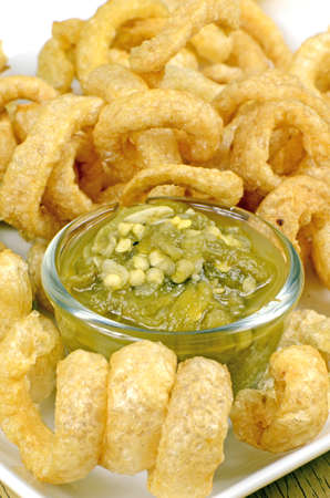 Pork snack, pork rind, pork scratching or pork crackling appetizers served with Northern Thai Green Chili Dip.の写真素材