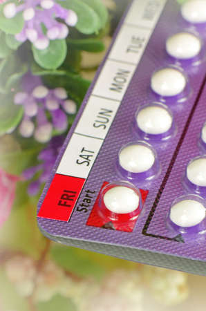 Contraceptive Pills with Day Labeled on Start Date with Soft Floral Background.の写真素材