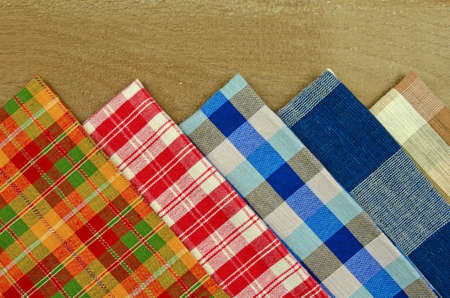 Collection of Thai Handmade Tablecloth Made from Cotton and Silk Display on Old Wood Table Surface as Background.の写真素材