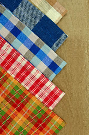 Collection of Thai Handmade Tablecloth Made from Cotton and Silk Display on Old Wood Table Surface as Background.の写真素材