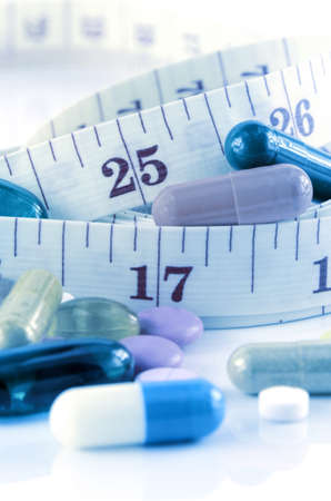 Medicine and Tape Measure on White Background in Waistline and Weight Control Concept.の写真素材