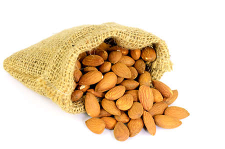 Baked Almond Nut (Prunus dulcis) in Berlap Sac Isolated on White Background.の写真素材