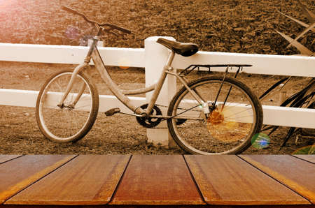 Old Bicycle in the Evening Light Background with Wooden Table.の写真素材