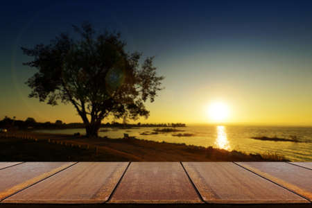 Perspective wood and Golden light over the lake with silhouette tree.の写真素材