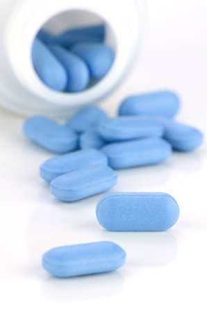 Blue caplets on white background.の写真素材