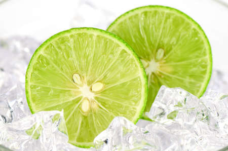 Cut lime (Citrus aurantifolia (Christm.)  Swingle) and ice on white Background.の写真素材