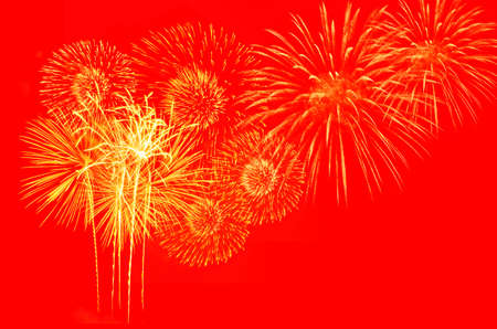 Gold fireworks on red background.の写真素材