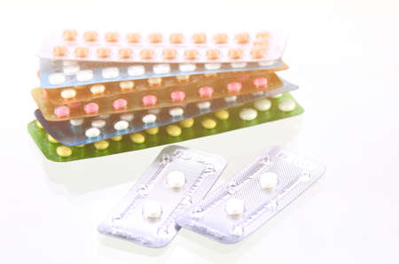 Emergency pills with oral contraceptive pills background in warm light tone.の写真素材