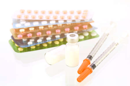 Parenteral contraceptive medications with oral contraceptive pills background in warm light tone.の写真素材