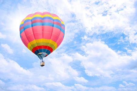 Colorful balloon over bright sky with clouds.の写真素材