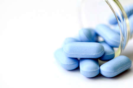 Blue caplets on white background.の写真素材