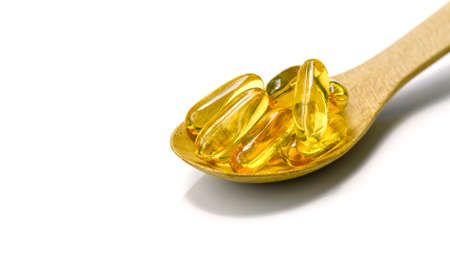 Spoonful of fish oil capsule isolated on white background.の写真素材