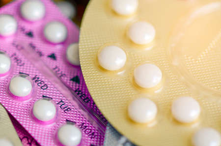 Oral contraceptive pill on pharmacy counter with colorful pills strips background.の写真素材