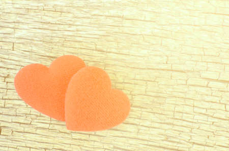 Two hearts on old wood background with soft light tone.