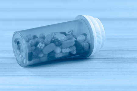 Oral medications in light protected bottle on pine wood table. Protect from light.