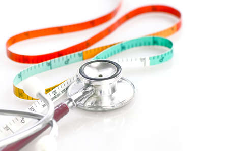 Measuring tape and stethoscope in weight and waist control concept.の写真素材