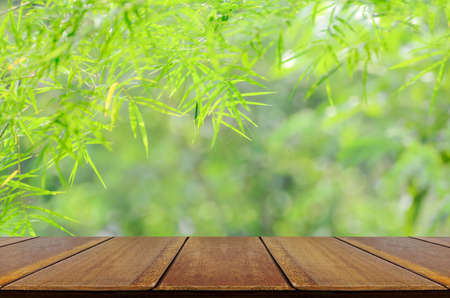 Empty wooden table over blurred bamboo forest with bokeh background.Background for product display, ready for product montage.の写真素材