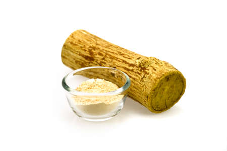 Thanaka wood and a cup of yellowish-white powder made from ground bark.の写真素材