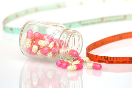 Medicine and Tape Measure on White in BMI, Waistline and Weight Control Concept.の写真素材