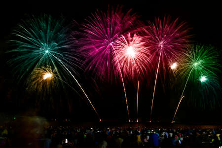 Colorful fireworks celebration and the night sky  with crowded people on the beach.の写真素材